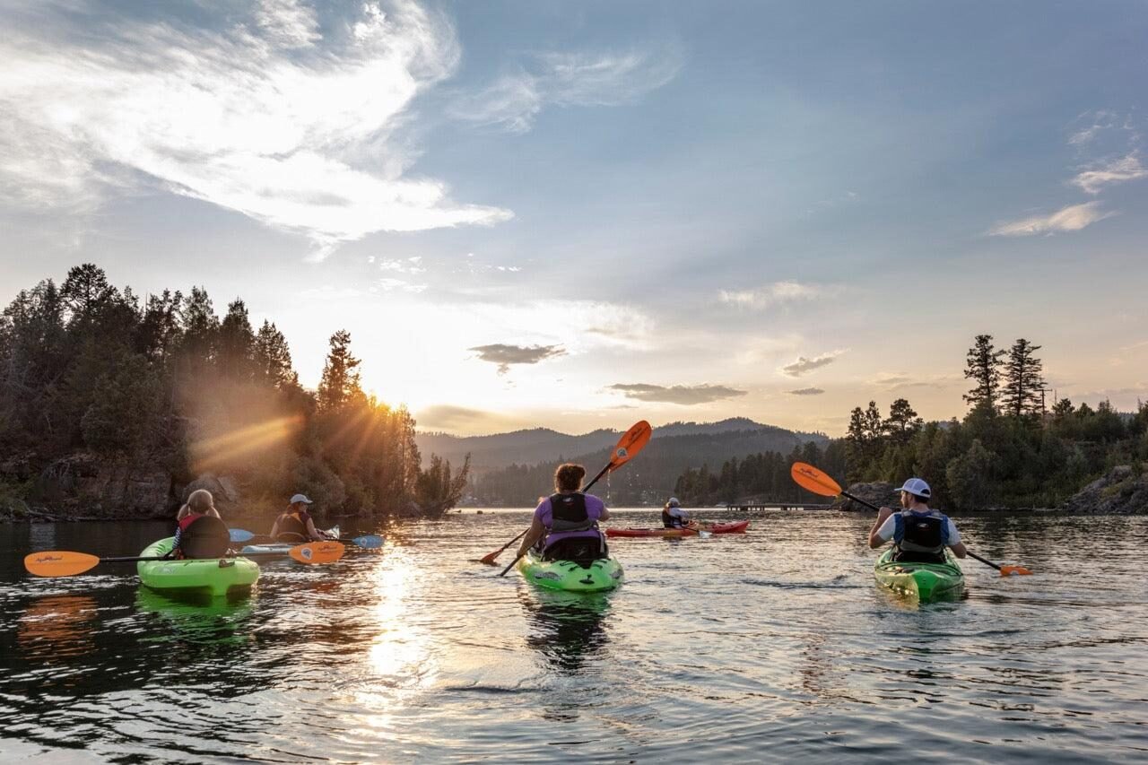 Group kayaking on the lake at golden hour
