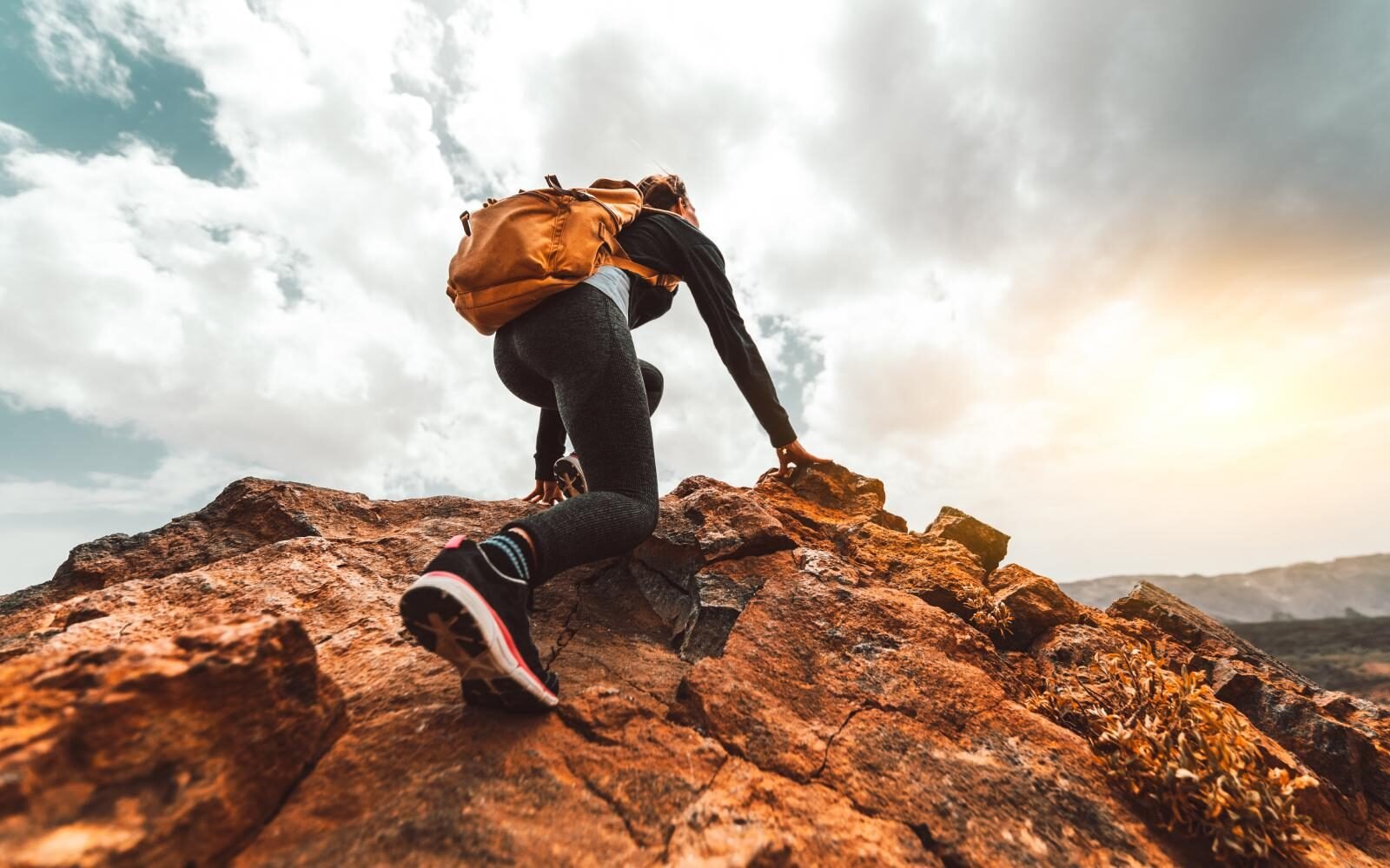 Climber scaling a rugged cliff face
